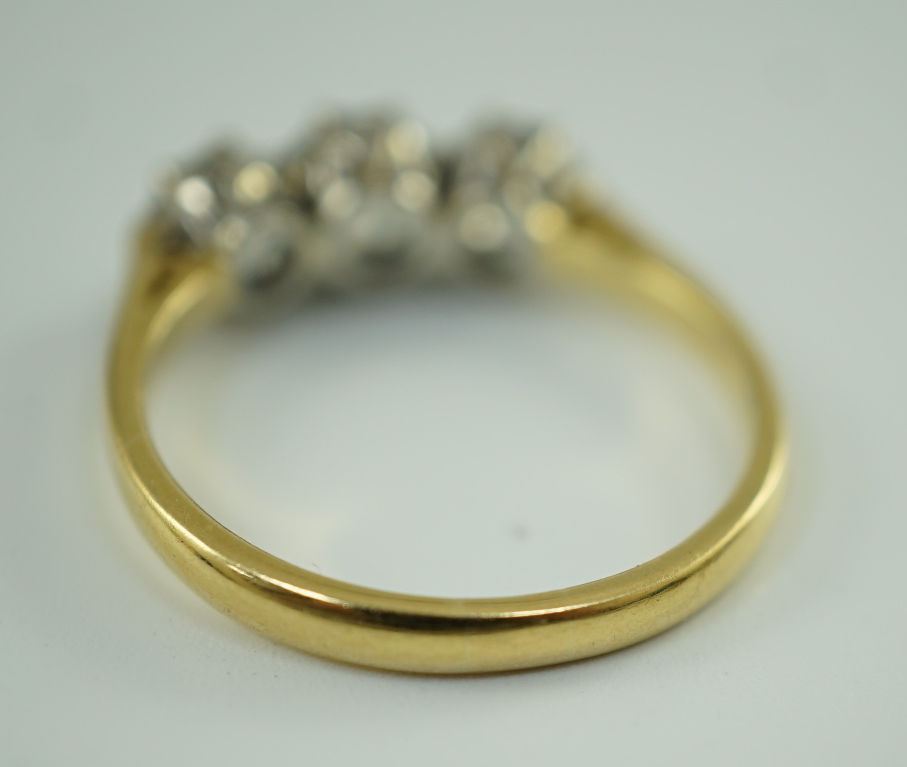 A modern 18ct gold and three stone diamond set ring